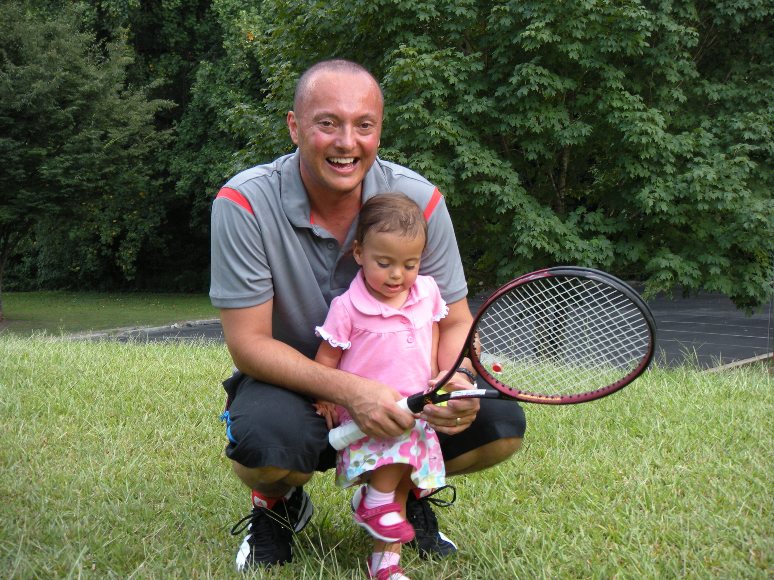 Coach Mike in the early days of Kidz Tennis programs pictured here with his daughter who is about 1-2 years old at the time.